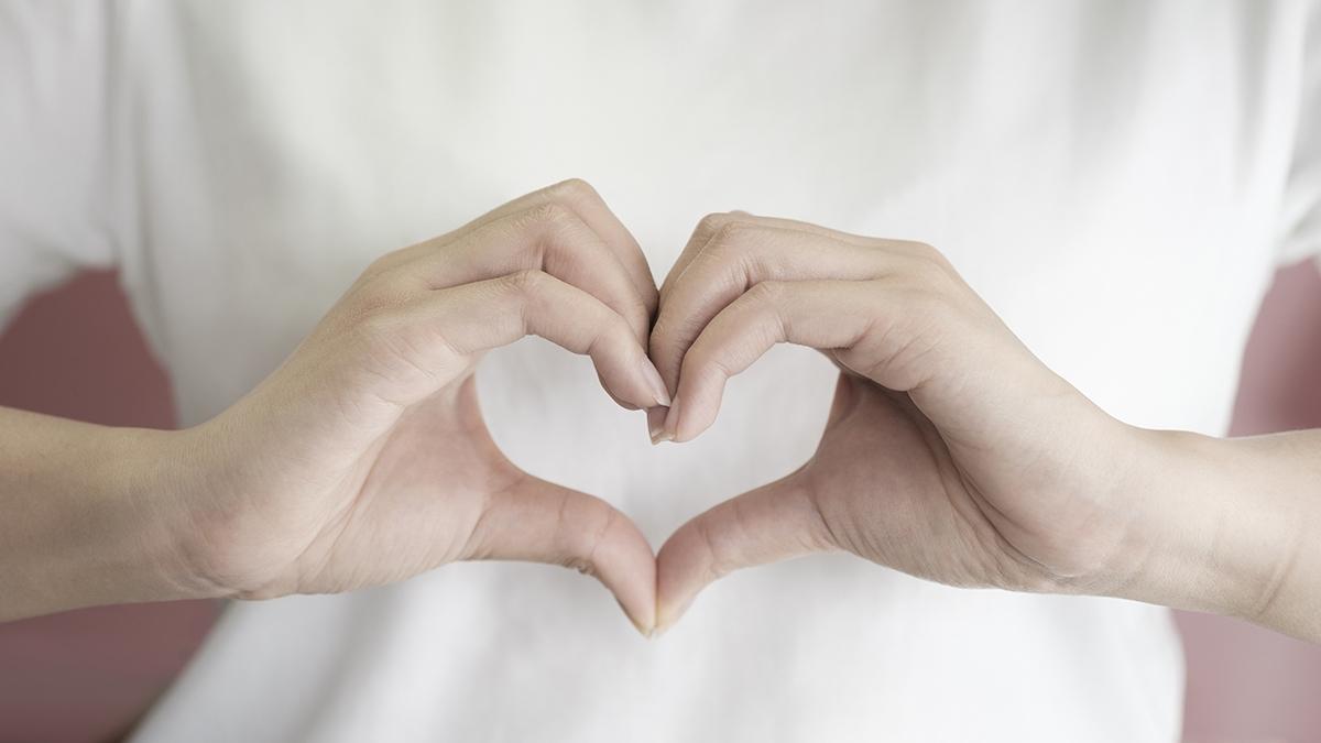 woman making hands in heart shape, heart health insurance, socia