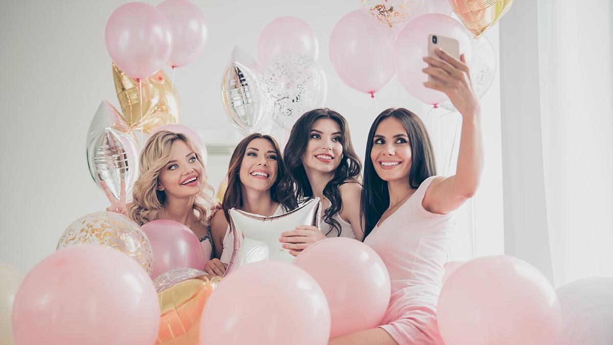 Portrait of nice cute lovely attractive charming cheerful glad girlfriends making taking selfie hugging baloon having fun in light white interior decorated house indoors