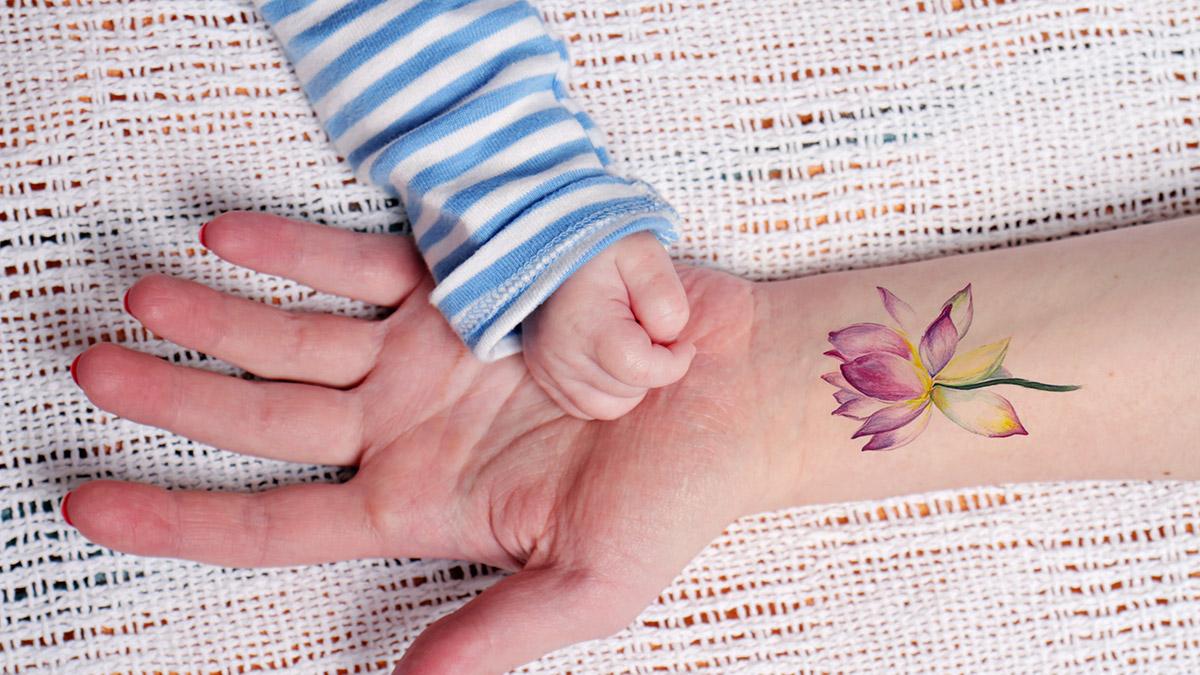 Mother holding baby&#;s hand close up. Hipsters,  Everyday Tattoos concept