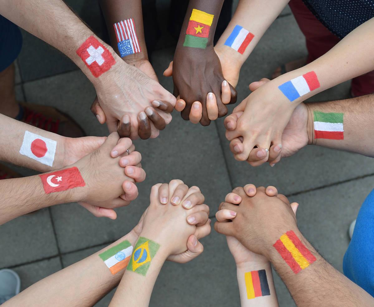 International brothers and sisters standing in a circle together and holding hands as a symbol for peace and the world community