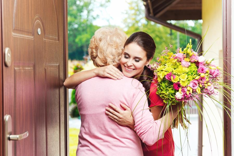 woman giving grandmother flowers