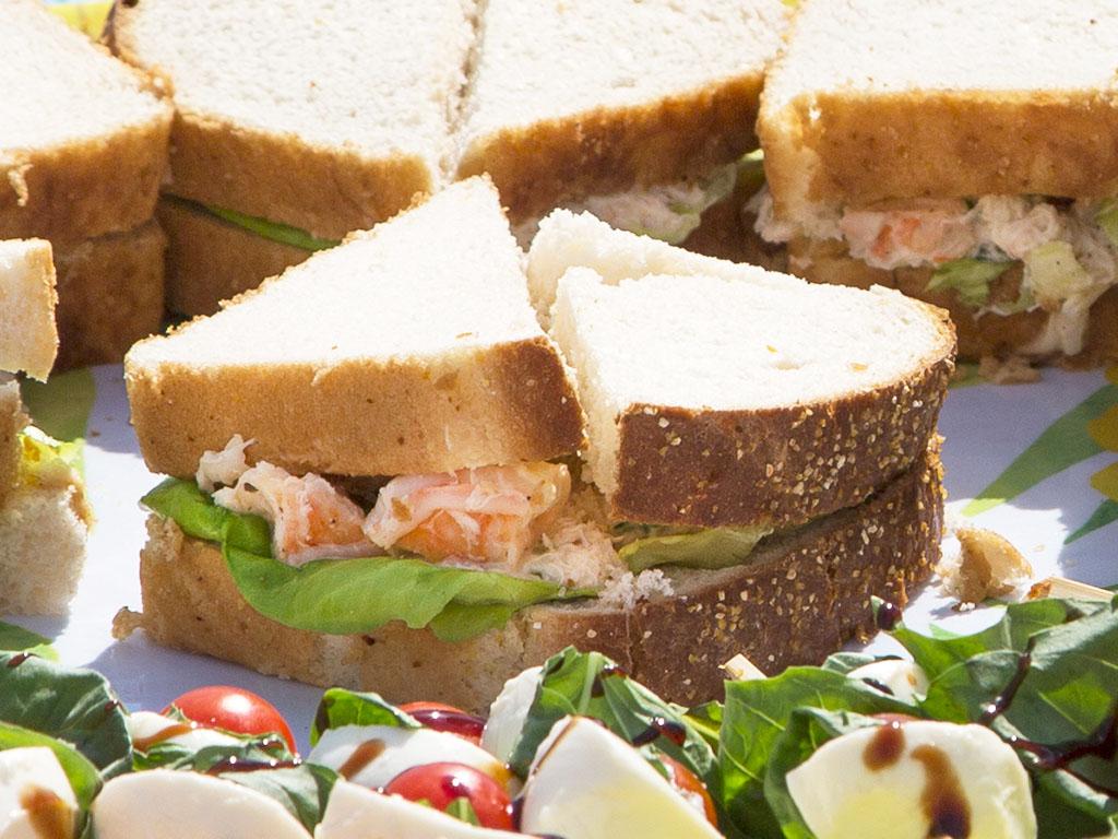 Photo of a seafood sandwich with shrimp and garlic relish on white bread and lettuce