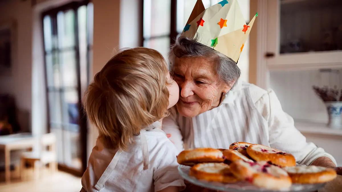 Why we wear party hats on birthdays with Grandma and grandchild at birthday party