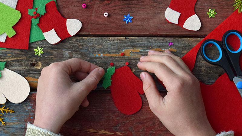 Making of handmade christmas toys from felt with your own hands. Children's DIY concept. Making xmas tree decoration or greeting card. Step . Decorate the toy