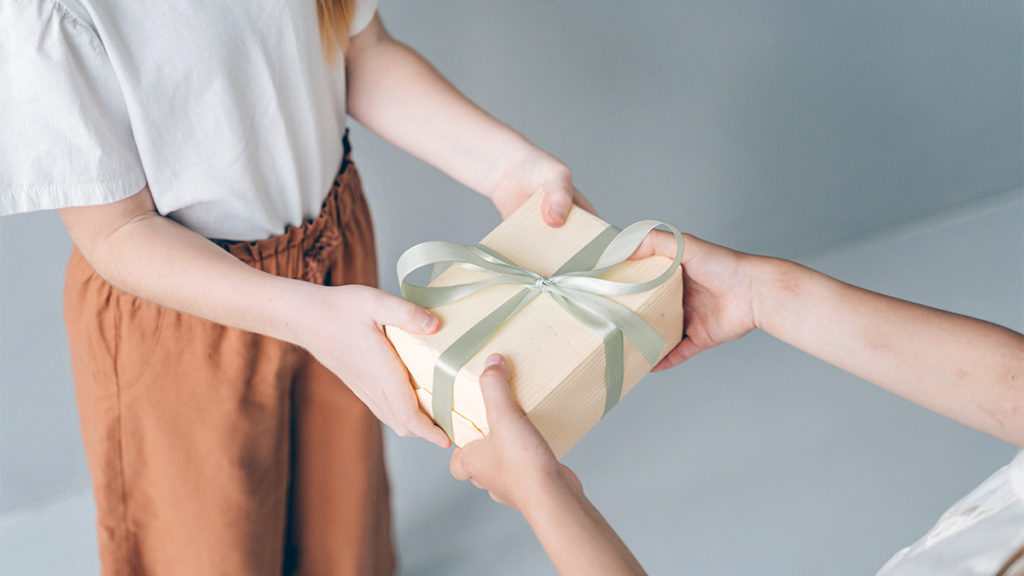 Photo of psychology of giving with a gift being exchanged.