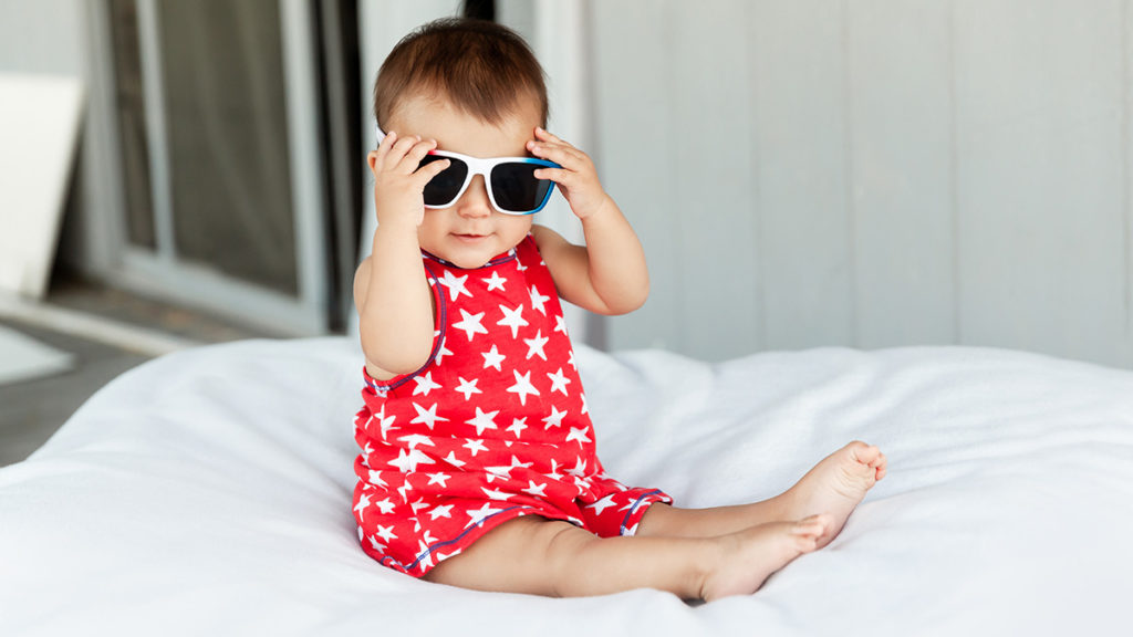 a photo of july birthdays with a baby dressed for the beach