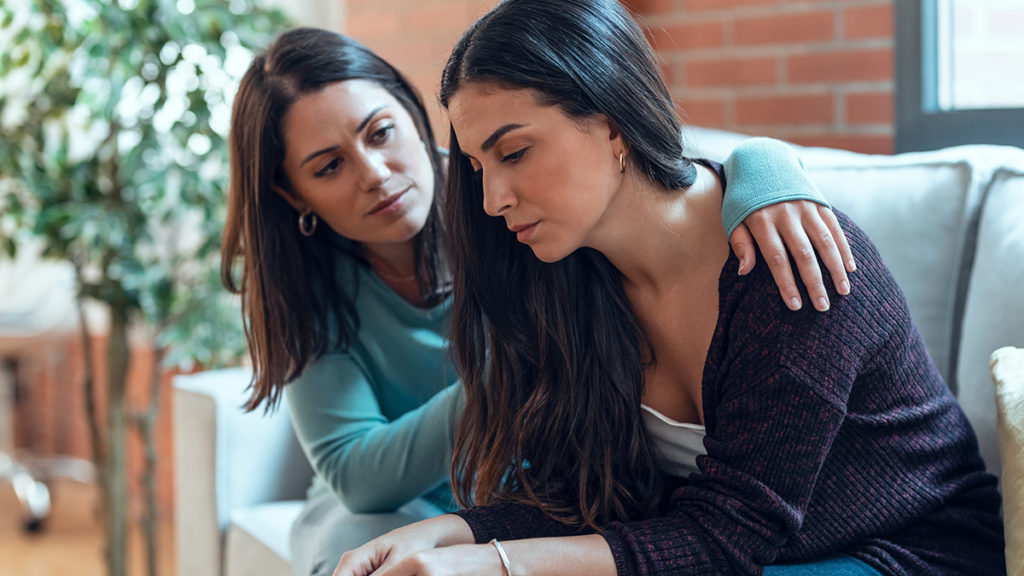 Photo of public tragedy with woman comforting a friend