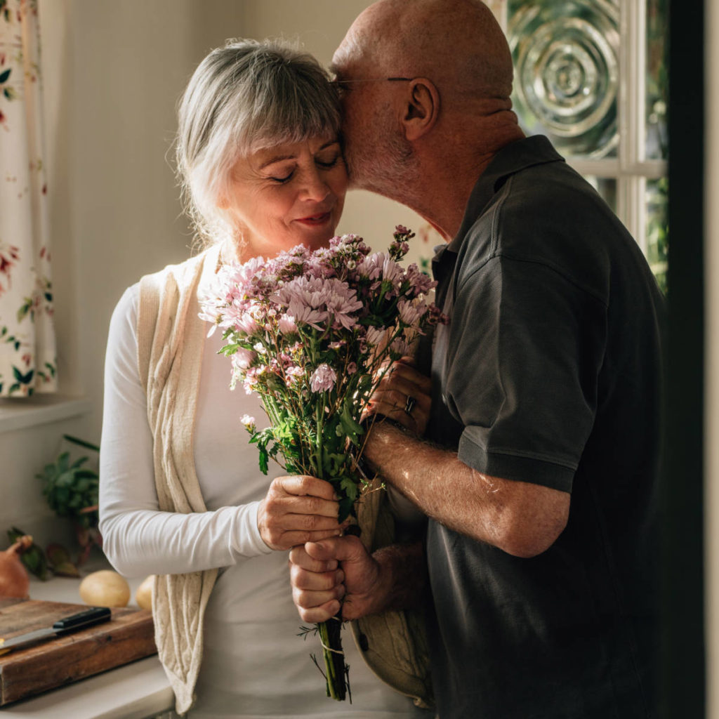 https://www.flowers.com/blog/wp content/uploads///history of gifting flowers with older couple giving flowers x