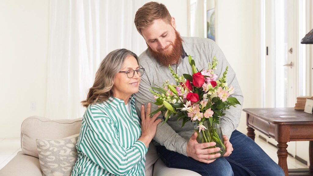 https://www.flowers.com/blog/wp content/uploads///international womens day ideas with son giving mom flowers x