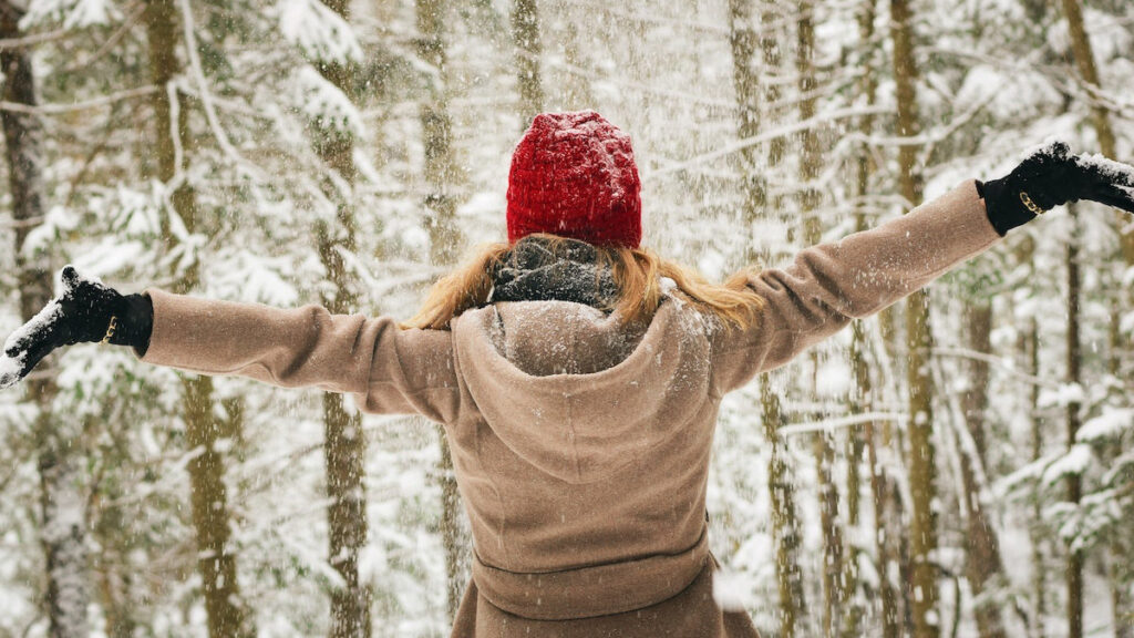 https://www.flowers.com/blog/wp content/uploads///winter quotes woman apreading arms in snow x