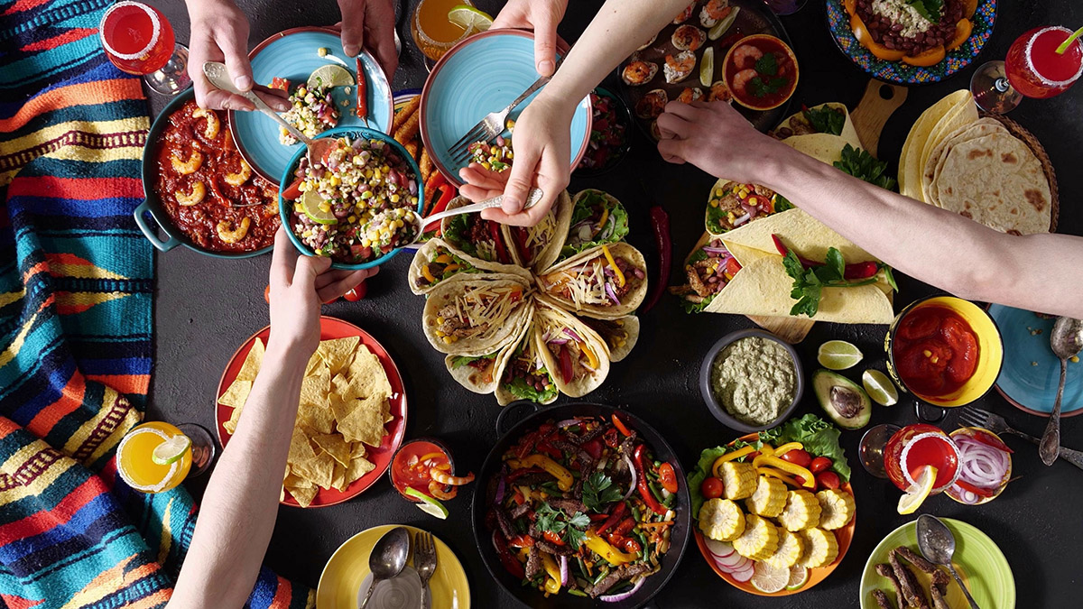 An authentic Mexican family celebrates Cinco de mayo together at a festive table. Mexican food